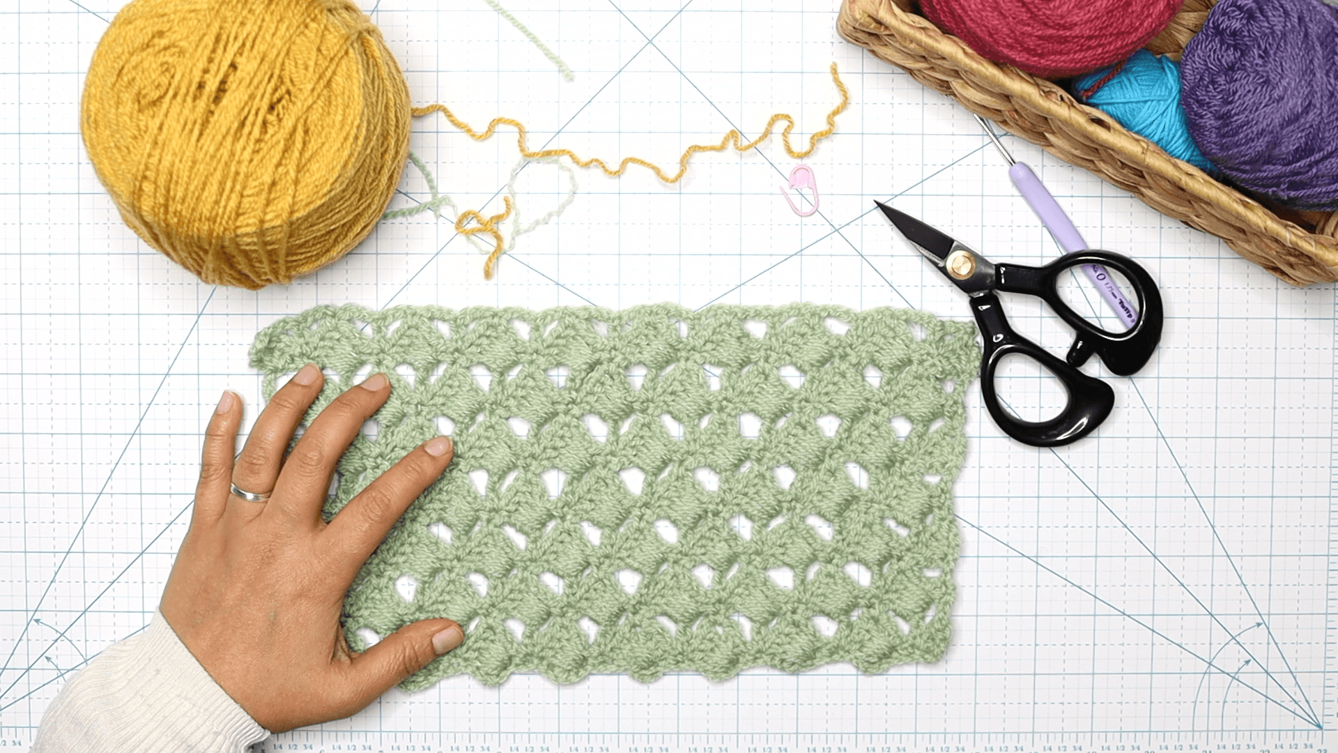 Elizabeth is showing an image of her desk top overview with the overlapping stitch on top of a cutting mat with other crochet tools