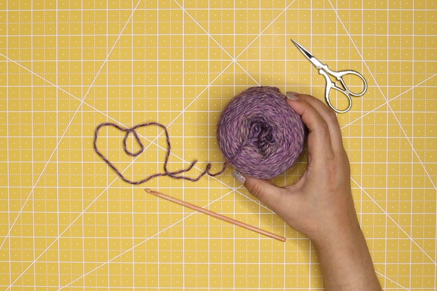 newly winded yarn being held on a yellow cutting mat